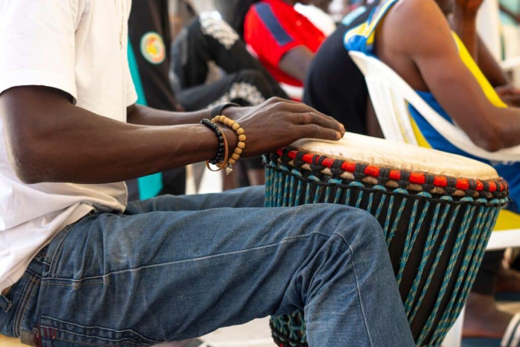 jeune homme qui tape le tam tam pour illustrer l'article sur la teranga senegalaise